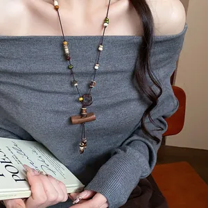 Detailed view of a long boho beaded necklace with wooden and ceramic accents.