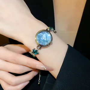 Detailed macro view of vintage women's star bracelet watch with sparkling green crystals