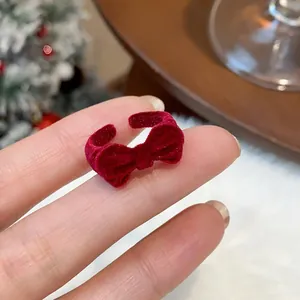 Detailaufnahme eines vintage roten beflockten Schleifenrings an einem Finger in Feststimmung