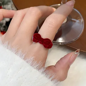 Nahaufnahme eines roten beflockten Schleifenrings für einen eleganten Winter-Stil am Finger