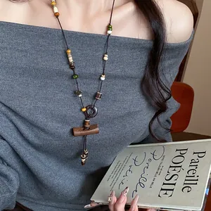 Bohemian beaded necklace with wood toggle pendant shown on a model holding an aesthetic book.
