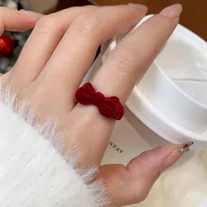Detailansicht eines roten Vintage-Flockbogenrings, getragen im Winter am Finger