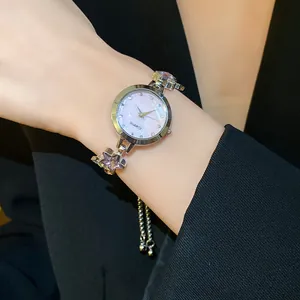 Close-up of a silver star bracelet watch with a lavender dial on a female wrist