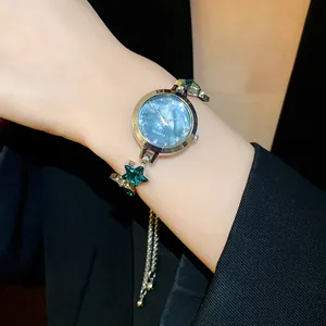Close-up of elegant star-shaped bracelet watch with shimmering teal dial