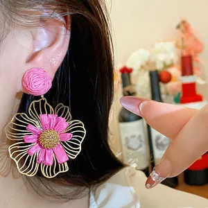 Detailansicht eleganter pinker Raffia-Blumenohrringe mit feinem Goldmetallrahmen