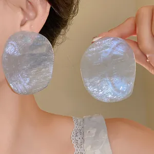 Close-up detail of iridescent prawn cracker style earrings with silver needle post