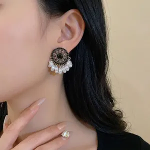Vintage ethnic style tassel earrings featuring white pearls and silver needle on model