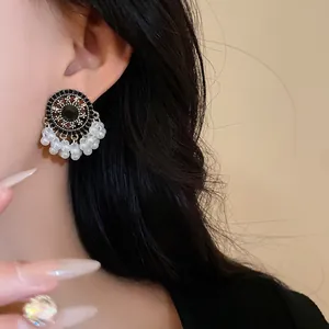 Close-up of vintage ethnic earrings with white pearl tassels and black rhinestones