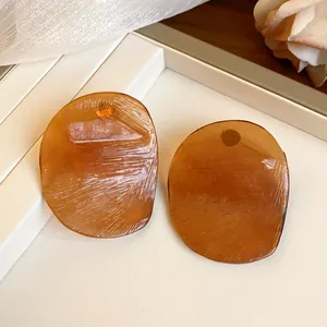 Close-up detail of vintage amber irregular round stud earrings with a unique textured surface