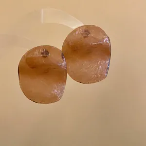 Close-up of vintage amber translucent curved disc earrings with unique prawn chip shape