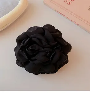 Close-up of a premium black fabric rose hair claw clip with elegant petal details.