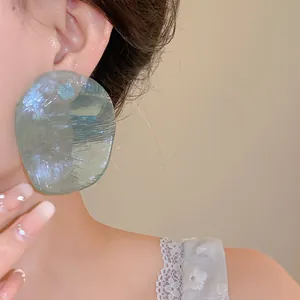 Large translucent light green resin stud earrings with vintage textured finish and silver pins