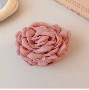 Detailed view of an elegant dusty pink fabric rose hair claw clip with petal texture
