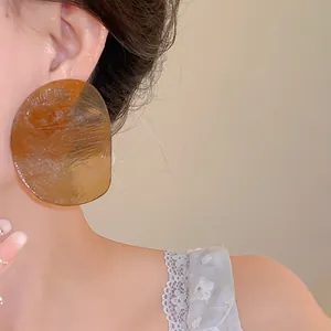 Close-up macro view of amber resin sheet earrings on model showing vintage minimalist style