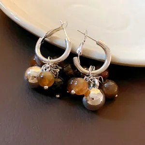 Primo piano di orecchini a cerchio vintage con sfere in resina e metallo argento