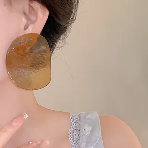 Macro view of amber translucent irregular shrimp chip earrings on a female model