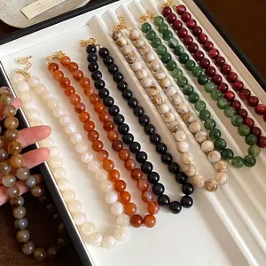 Colliers vintage élégants avec perles marbrées en plusieurs couleurs sur un plateau