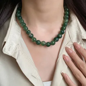 Élégant collier de perles vert foncé de style vintage porté par un mannequin en chemise