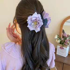 Elegant purple rose flower hair claw clip displayed on a romantic half-up wavy hairstyle