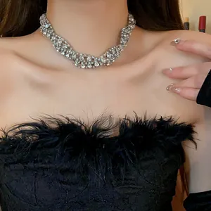 Close-up of sparkling rhinestone twisted braid necklace on model with feather lace top