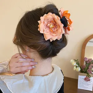 Elegant large peach rose flower hair claw clip shown on a woman for a romantic look.