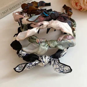 Close-up of elegant silk scarf wrapped bow headbands in various vintage patterns