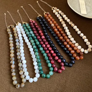 Vue détaillée de colliers de perles marbrées colorées avec texture vintage et chaîne