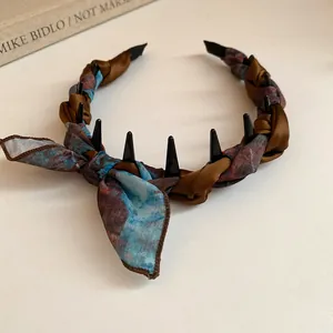 Close-up detail of retro fabric wrapped headband with bow and black styling teeth
