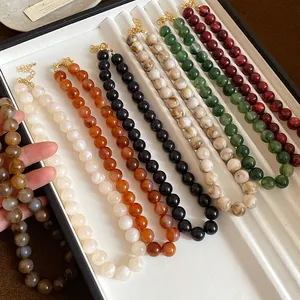 Gros plan de colliers de perles marbrées de plusieurs couleurs pour un look vintage