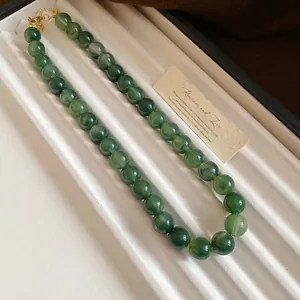 Vue détaillée de perles vertes avec motif marbré sur un collier de perles vintage