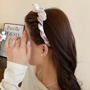 Elegant fabric silk scarf wrapped headband with bow decoration shown from side