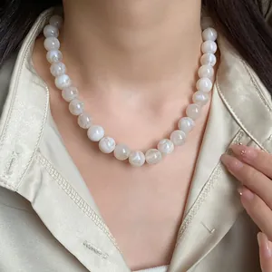Vue détaillée d'un collier de perles marbrées sur un mannequin en chemise satinée