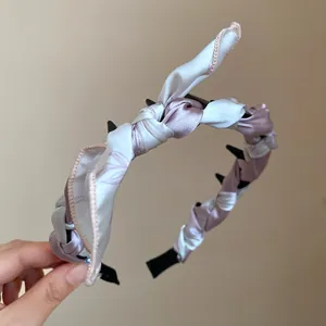 Close-up of elegant silk scarf wrapped headband with a stylish floral bow detail