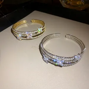 Dettaglio di bracciali aperti a fiori in zircone multistrato con effetto brillante
