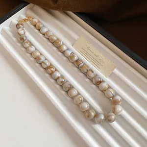 Vue détaillée de perles marbrées élégantes sur un collier de mode style vintage