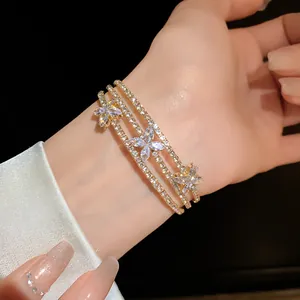 Primo piano di un bracciale multistrato dorato con fiori in zircone scintillante