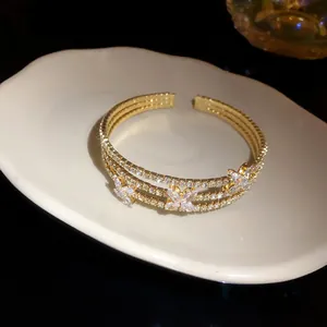 Dettaglio di un elegante bracciale a fiori dorato con brillanti zirconi cubici