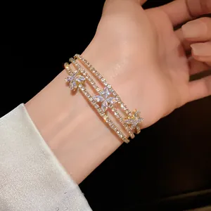 Vista dettagliata di un elegante bracciale in oro a tre strati con fiori di zirconi
