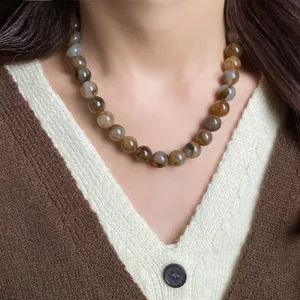 Vue détaillée d'un collier de perles marbrées porté sur le cou au style vintage