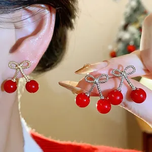 Elegant red cherry earrings with metallic bow design and silver needle posts for women