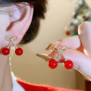 Elegant red cherry stud earrings with golden bowknot detail and silver needles for women