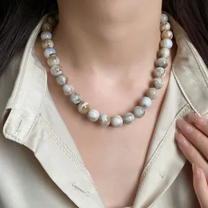 Vue détaillée de perles marbrées vintage sur un collier ras du cou élégant et chic