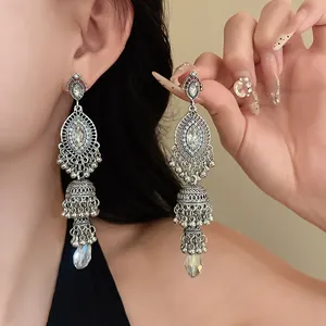 Close-up detail of vintage palace style crystal drop earrings with filigree jhumka bells