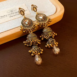 Close-up detail of vintage palace style golden dangling earrings with rhinestones