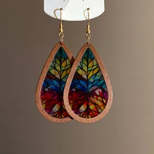 Macro detail of bohemian teardrop wood earrings with colorful stained-glass patterns