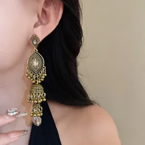 Close-up view of vintage palace style jhumka earrings featuring rhinestones and pearls