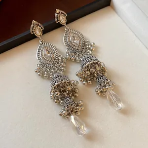 Detailed macro view of vintage silver jhumka earrings with clear crystal teardrops