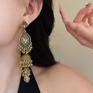 Close-up detail of vintage court-style gold chandelier earrings with amber-colored crystals