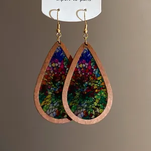 Detailed view of bohemian teardrop earrings with vibrant stained glass print and wooden frame.