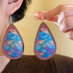 Close-up view of bohemian wood teardrop earrings with colorful stained glass print